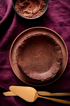 Chocolate Basque Cheesecake with Cocoa and Serving Utensils