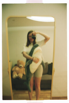 TITLE:
Blurry Mirror Selfie With Film Camera and Teddy Bear at Home
