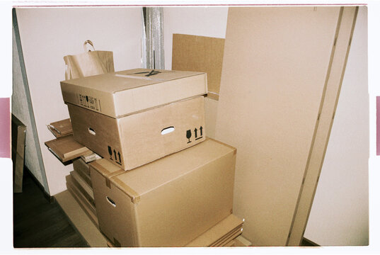 Stacked Cardboard Moving Boxes in Empty Room, Film Photo