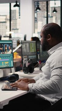 Vertical Video Video editor, film footage on computer, editing cinematic motion graphics project. Black man using software toolbar and sliders to edit montage, cutting recorded clips and adjusting