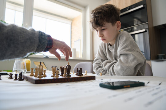 Kid Plays Chess With Adult in Modern Kitchen 