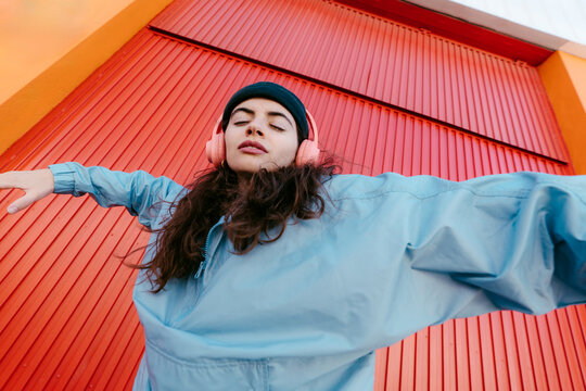 Colorful urban portrait of woman dancing with headphones
