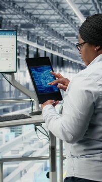 Vertical video Businesswoman monitoring PCB smart factory workflow using AI deep learning EDA software. African american female manager uses artificial intelligence simulation to track microchip