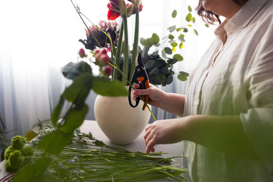 Florist Arranging Bouquet With Pruning Shears Indoors