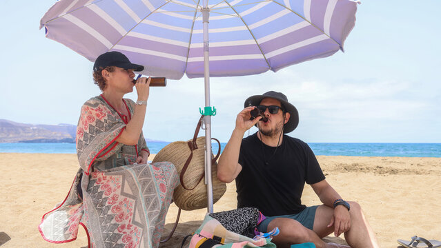Couple Relaxing Under Beach Umbrella on Sunny Day