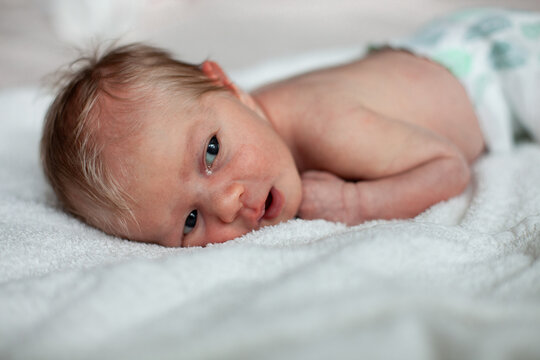 Awake Newborn Baby Lying on Soft White Blanket