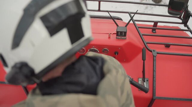 Helmet view over red atv dashboard, helmeted rider accelerating with hands on throttle, gauges flickering, snow spray from front tires, fast nimble maneuvering for high energy offroad run