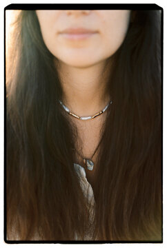 Detail of woman necklace and long dark hair
