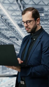 Vertical video Looking at data, laptop and portrait of cheerful man improving microchips fabrication supply chain yield. Visualizing semiconductors production, bottlenecks and Jolly manager in using