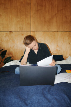Person managing finances paying utility bills from bed