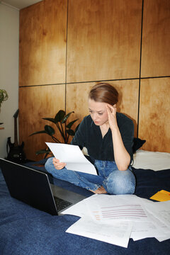 Person calculating finances and paying utility bills on laptop