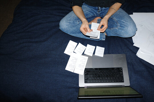 Person managing finances, reviewing utility bills on laptop