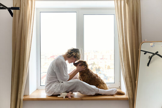 Woman Bonding with Dog by Window at Home