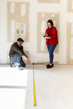 Interior designer and architect taking measurements 
