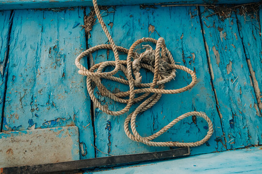Coiled Rope on Weathered Blue Boat Deck
