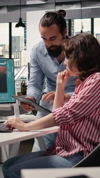 Vertical Video Graphic editors generate images from prompts with text to image software, performing photo retouching. Diverse staff collaborating with artificial intelligence technology on monitor.