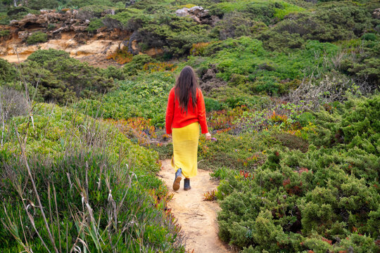 Indigenous woman walking on path by the sea