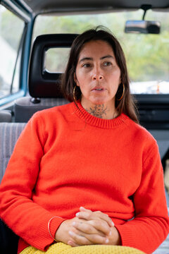 Indigenous woman sitting inside an old Camper van