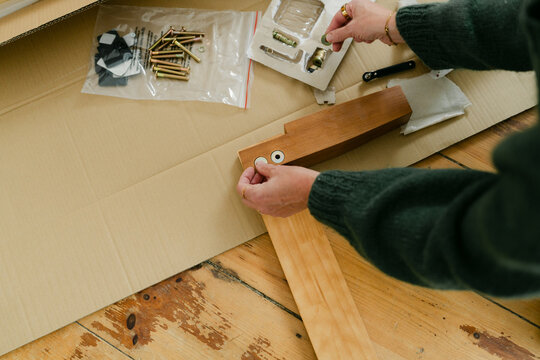 Anonymous woman putting bed together 
