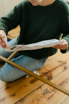 Anonymous woman putting bed together with instructions