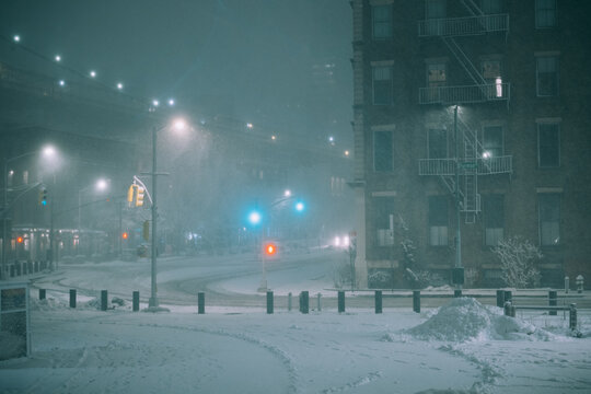 Snowy City Intersection Beneath Brooklyn Bridge at Night