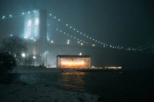 Carousel Pavilion Beneath Brooklyn Bridge on Foggy Winter Night
