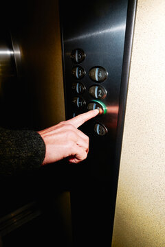 a man presses the 0 button in the elevator