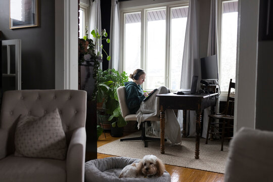 Seated Girl listening to music, and working. 