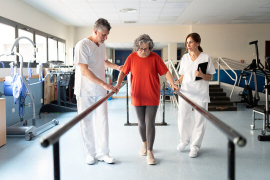 Elderly woman doing physical therapy with medical staff