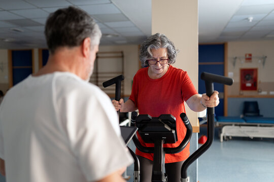 Senior woman exercising on elliptical machine rehabilitation