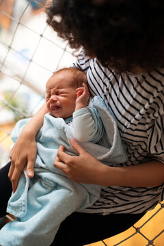 Mother Holding Newborn Baby Wrapped In Blue Blanket