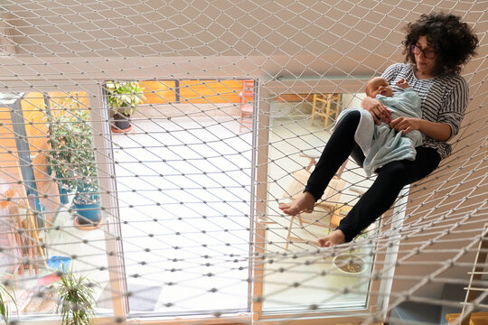 Mother Holding Newborn on Indoor Safety Net Hammock