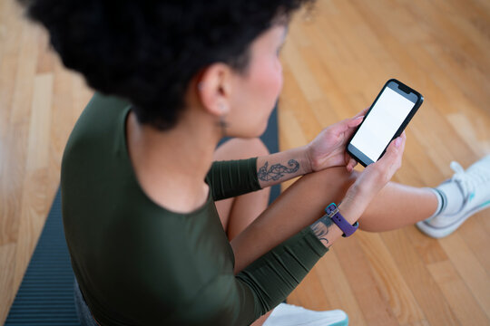 Woman using phone during workout in gym