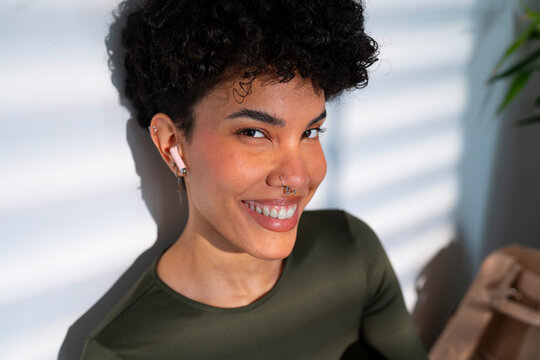 Woman smiling while sitting indoors by a window