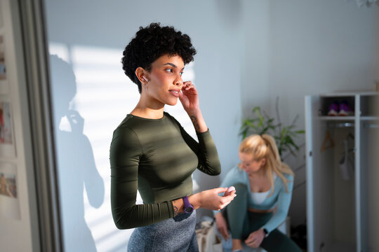 Women prepare for workout in gym setting