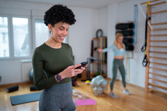 Woman uses phone in gym during workout session