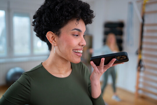Woman talks on phone in fitness studio