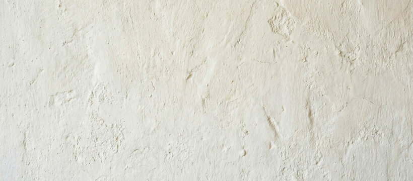 A close-up view of a textured white wall, showcasing its intricate surface details and subtle variations in color and shadow, ideal for backgrounds and design elements.