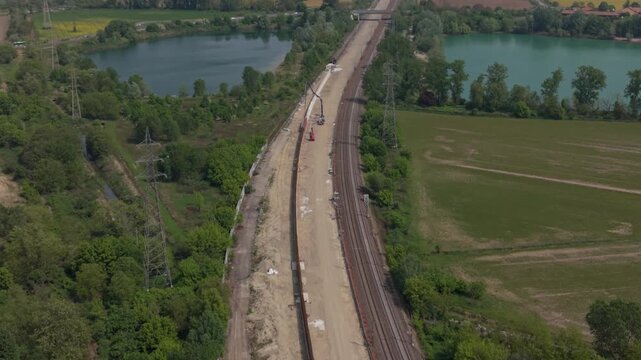 Railway Construction in Rural Landscape: An aerial view captures ongoing railway construction and expansion through a serene rural landscape, showcasing the integration of infrastructure with nature.