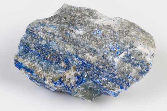 Lapis lazuli slab with glittering pyrite rich ultramarine pockets rough polished edges and tactile texture ideal for artisan pigment or jewelry cutting in warm studio mood