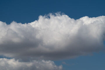 Obraz premium Calm sky scene. Bright fluffy clouds with sunlight. Serene sky bathed in gentle sunlight and clouds. Peaceful blue sky filled with soft clouds and radiant sunlight