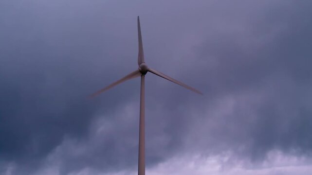 Wind turbine standing tall against a dramatic, cloudy sky, producing renewable energy and symbolizing sustainable power generation at Serra da Boneca, Portugal