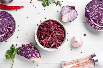 Naklejka premium Bowl of tasty red sauerkraut with peppercorns, onion, garlic, parsley and sea salt on white wooden background
