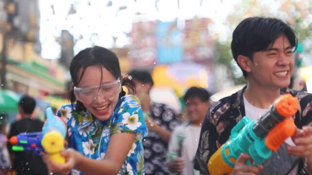 Happy Asian Couple Playing with Water Guns at Songkran Festival in Bangkok