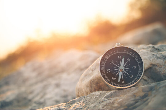 The compass of travel points towards the sun setting in the warm sunlight.