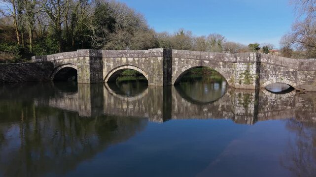 Historical Stone Bridge Over The Xallas River - Brandomil Roman Bridge In Zas, Galicia, Spain. Aerial Zoom In Shot