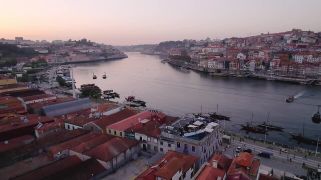Douro River with Teleferico de Gaia cable car and rabelo boats in Porto municipality Porto district Norte region Portugal along Av de Diogo Leite waterfront, backward orbit reveal drone shot