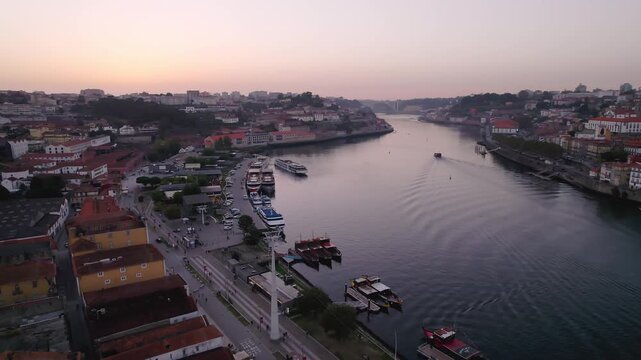 Douro River between Porto municipality and Vila Nova de Gaia Porto district Norte region Portugal with river traffic rabelo boats and cruise ships along Av de Diogo Leite, drone forward glide shot