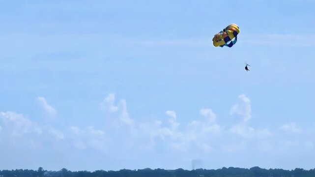 A vacationer at a resort in Lapulapu City, Phillippines, enjoys the thrill of a parasail ride above Hilutungaan Channel, between Mactan Island and Olango Island.