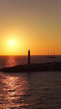 Vertical Lighthouse Silhouette at Fire Sunset with Sailing Boats, Punta Nati Menorca Travel Scene
